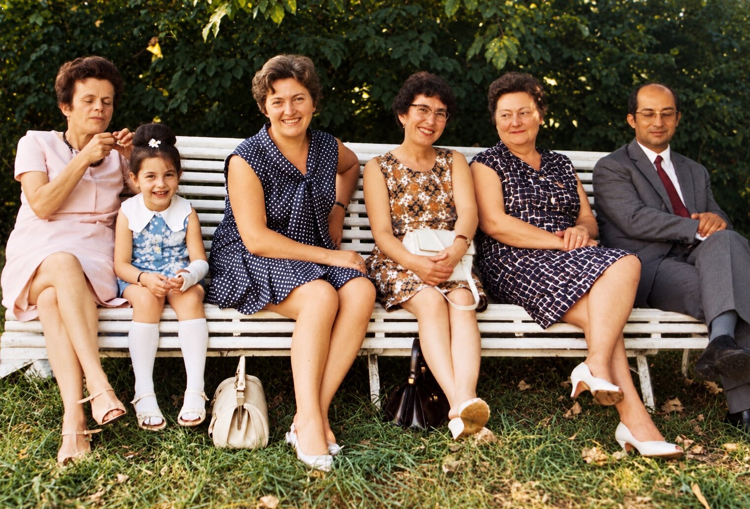 Marcelle, Yvonne, Gilberte et Germaine assises sur un banc, avec une petite fille et un homme