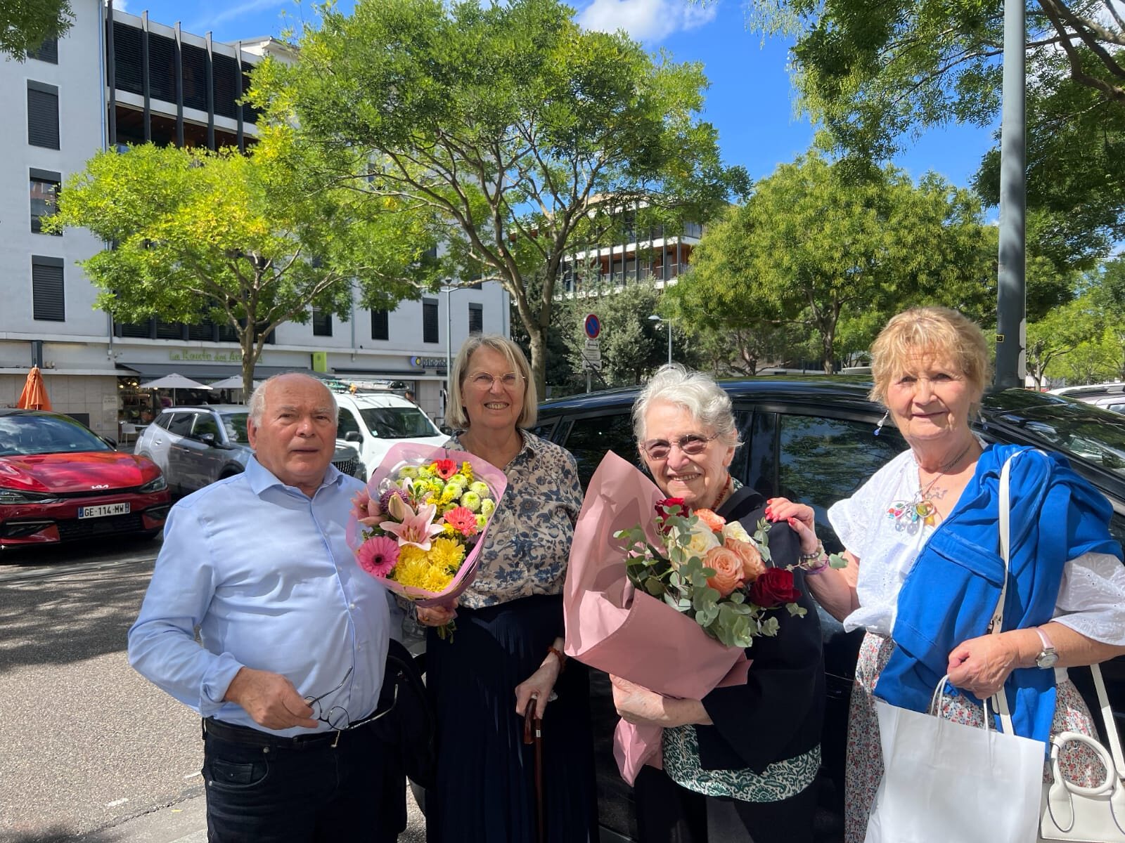 Yvonne entourée de proches, un bouquet de fleurs dans les bras